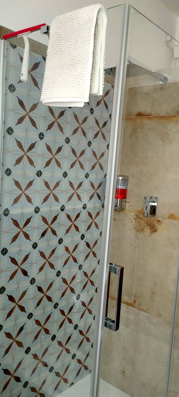 La doccia del bagno principale con il rivestimento a cementine decorate