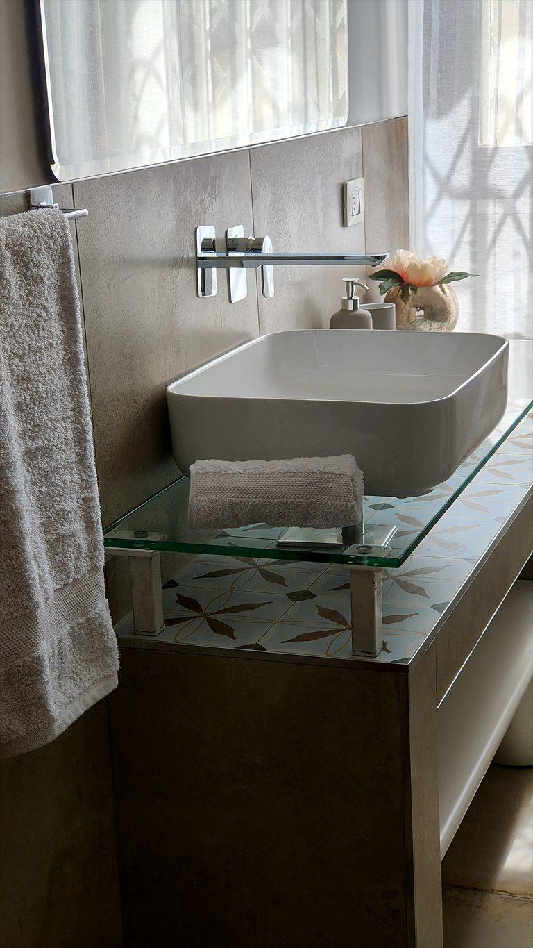 Dettaglio del lavabo del bagno principale con rubinetteria a muro