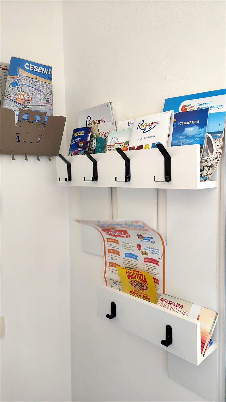 Il portadepliant all'ingresso di Casa Plac con le mappe di Cesenatico, di Rimini e della Romagna